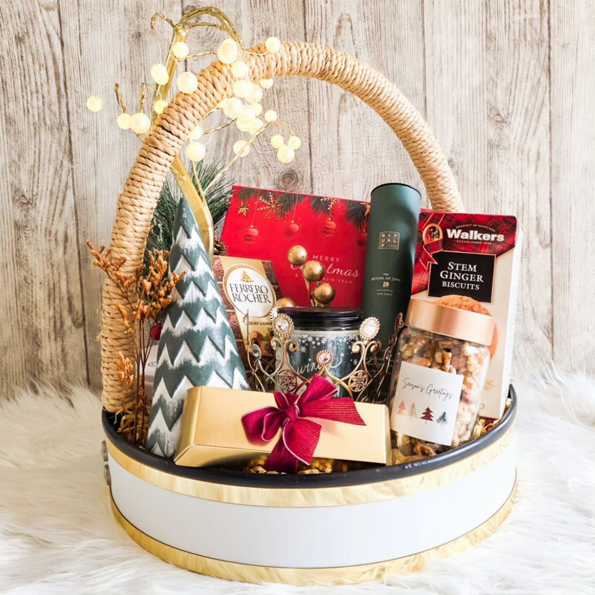 Gourmet gift basket with chocolates, biscuits, and nuts in a woven wicker basket.