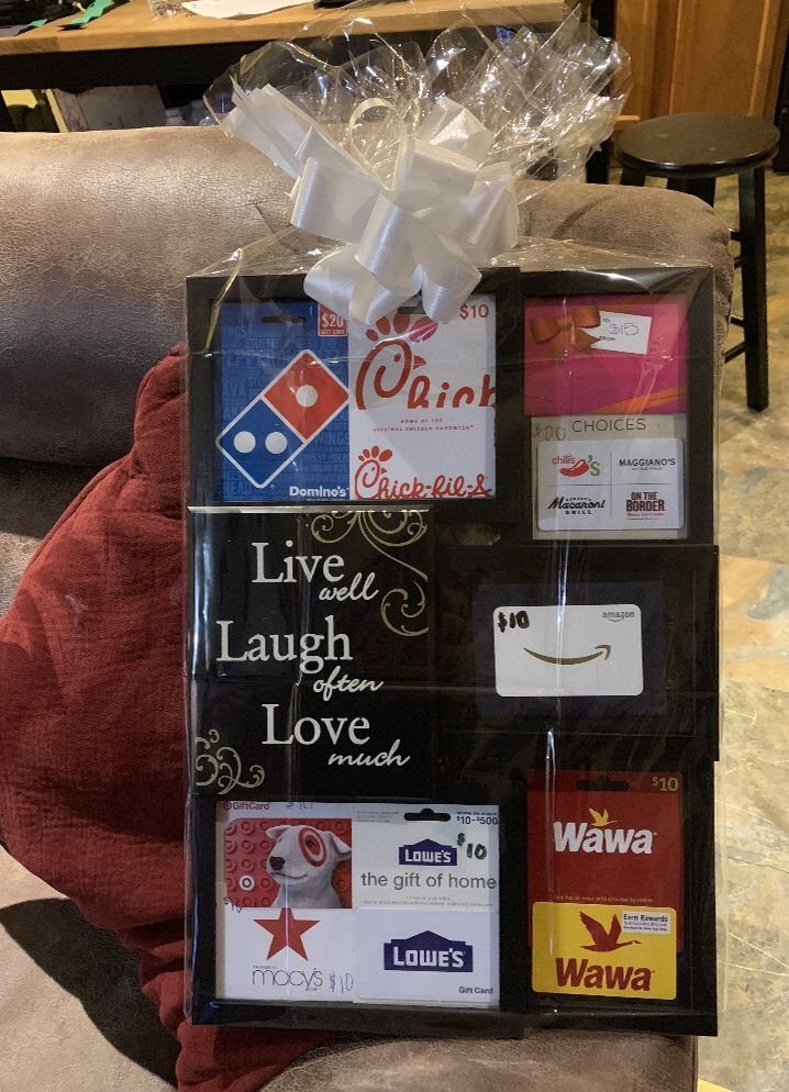 Framed collage of multiple gift cards wrapped in cellophane with a white bow.