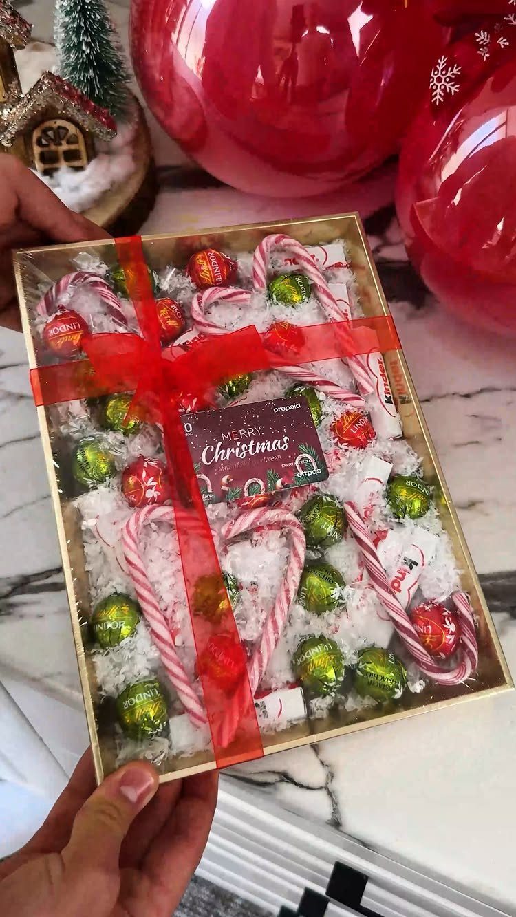 Gift box with red Christmas gift card, candy canes, and foil-wrapped chocolates.