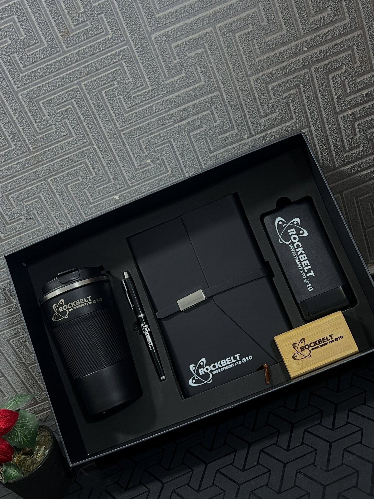 12 Gift Ideas for the Office Your Coworkers Will Use 4 Black corporate gift set with travel mug, notebook, pen, and power bank.