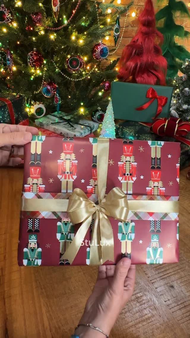 Gift wrapped in burgundy nutcracker pattern paper with a gold satin bow.