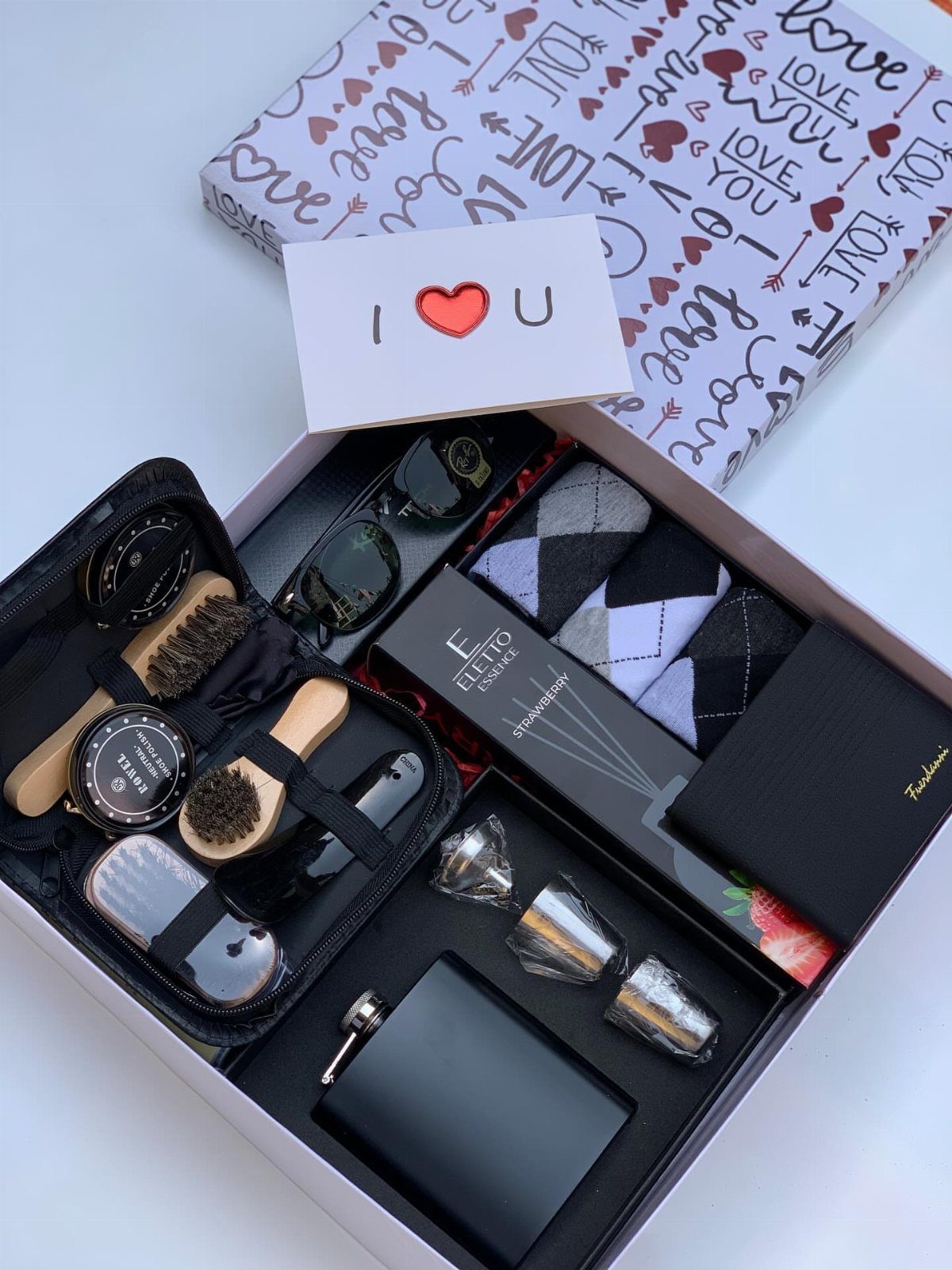 Gift box containing grooming tools, socks, and a wallet with love-themed wrapping paper.