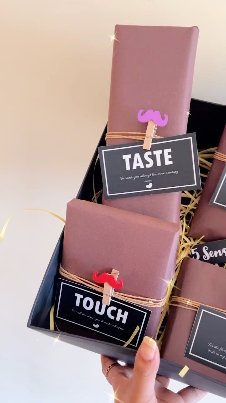 Brown wrapped gifts in a black box with labels for taste and touch.