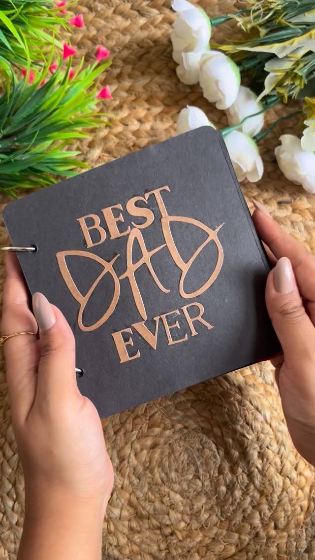 7 Gifts for Dad From Son That Feel Personal and Fun 6 Black notebook with Best Dad Ever cutout held by hands on woven mat