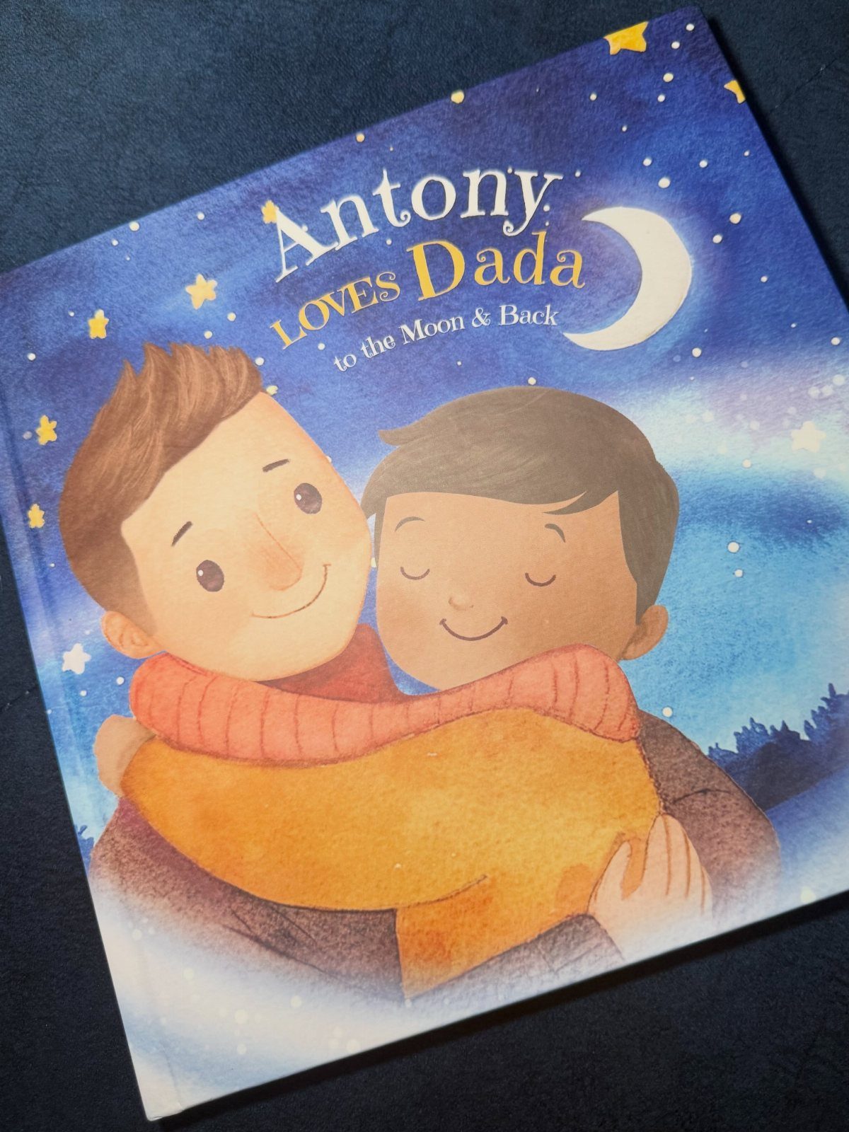 7 Gifts for Dad From Son That Feel Personal and Fun 5 Children's book cover showing a father and son hugging under a starry sky.