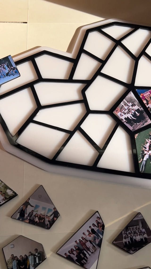 Heart-shaped geometric photo frame with small group pictures and loose photo tiles.