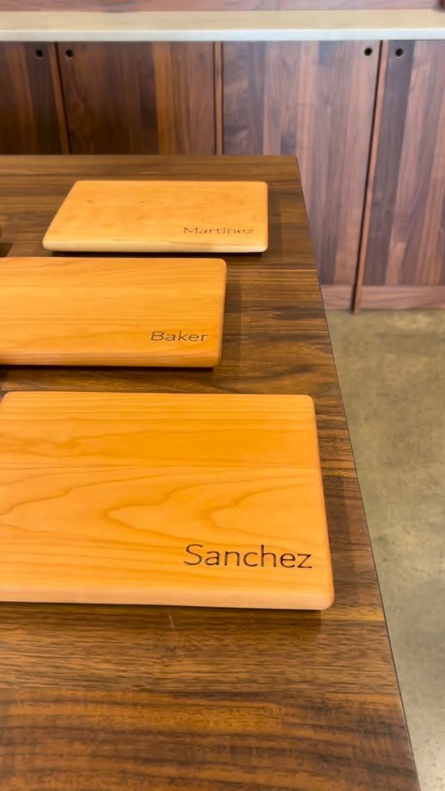 6 Gifts for Grandpa Who Has Everything: Personal Picks 6 Three wooden cutting boards with engraved family names on a dark wood table.