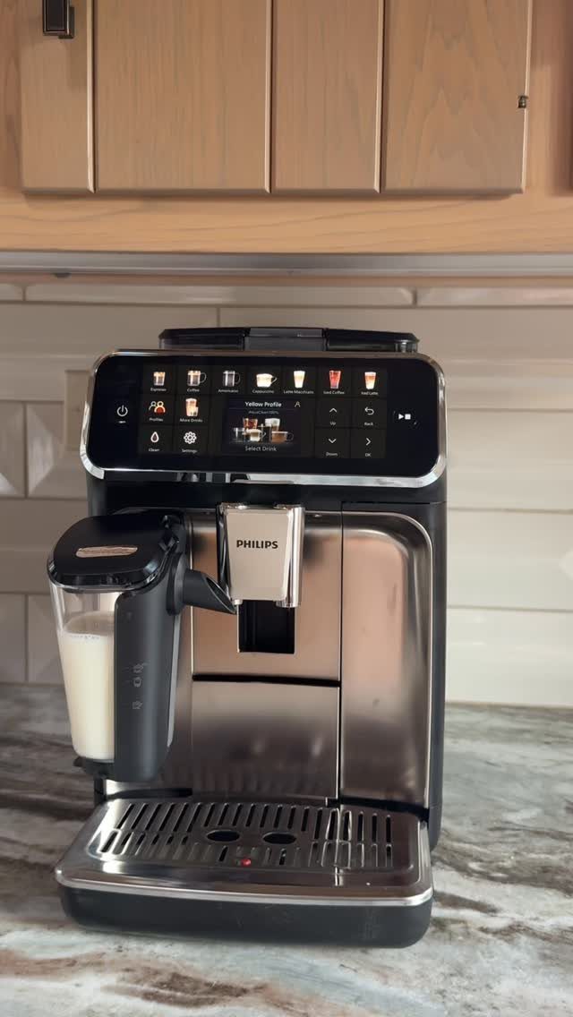 Philips automatic espresso machine with milk carafe on a marble kitchen countertop