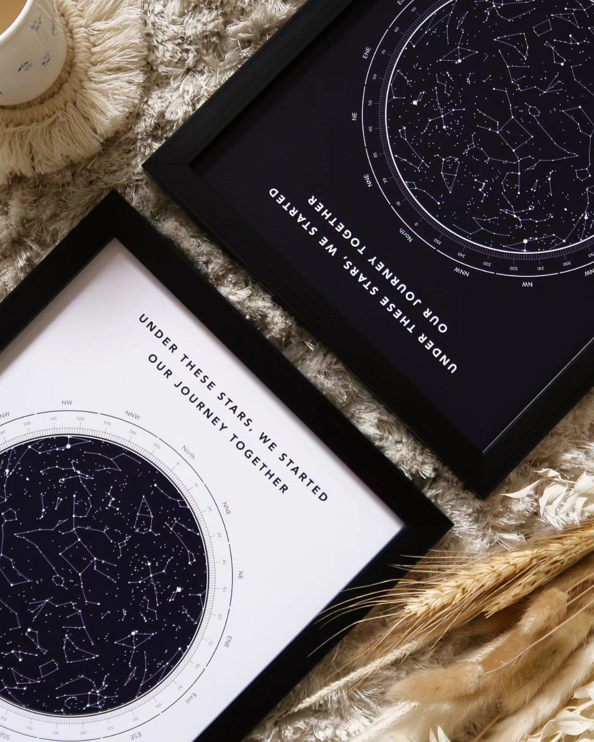 Two framed star maps with romantic text resting on a beige textured surface.