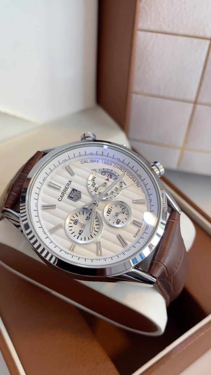 Silver luxury wristwatch with brown leather strap in a brown presentation box