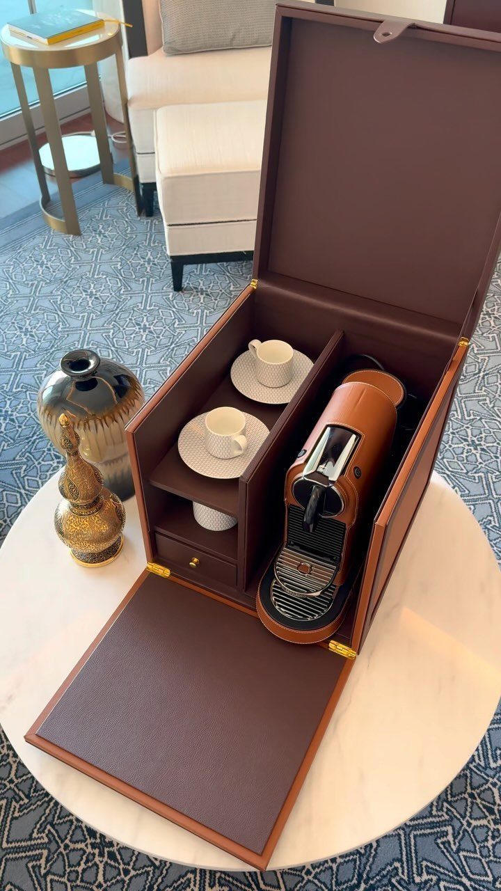 Luxury leather travel coffee station with Nespresso machine and espresso cups on marble table