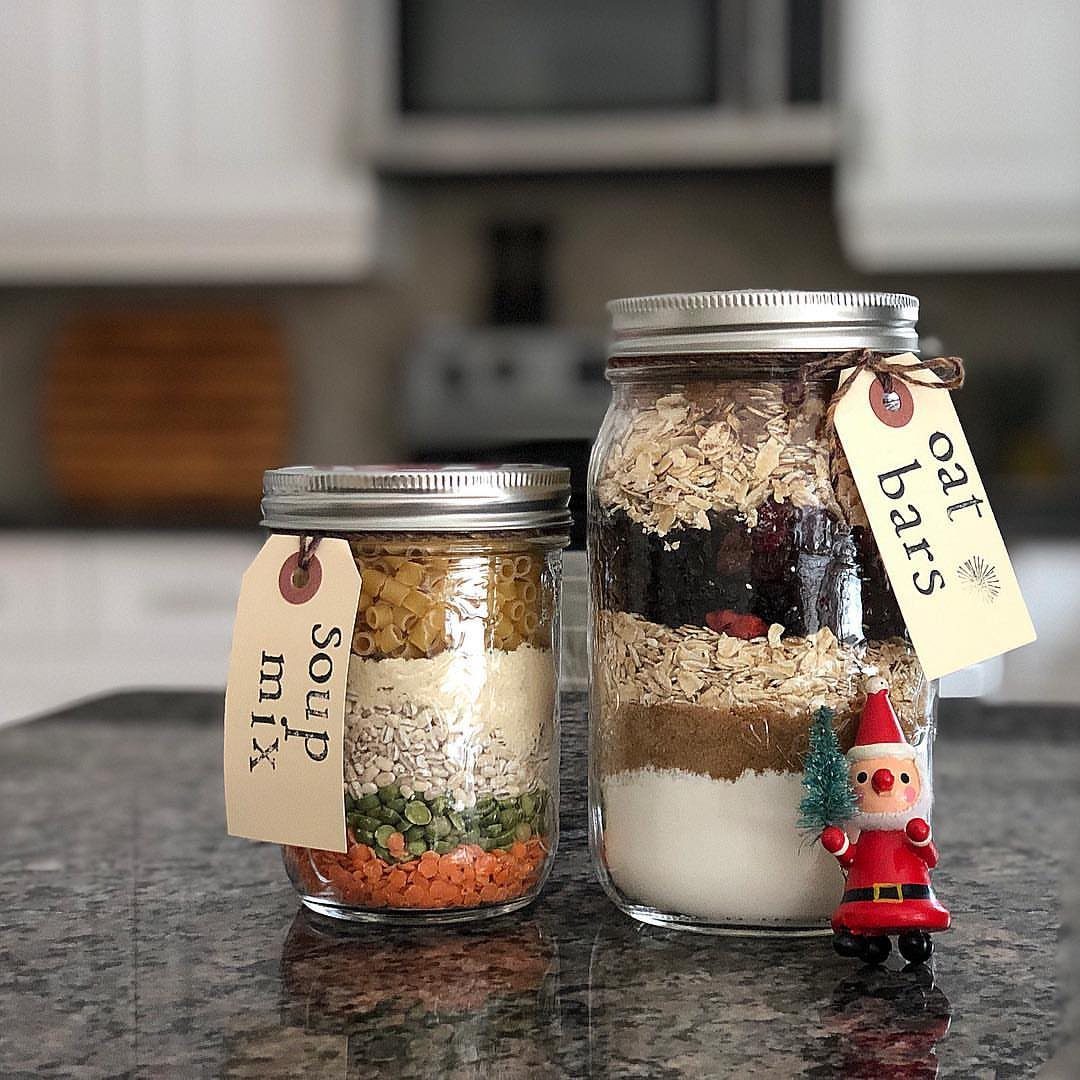 Two mason jars filled with layered dry food mixes on a granite counter.