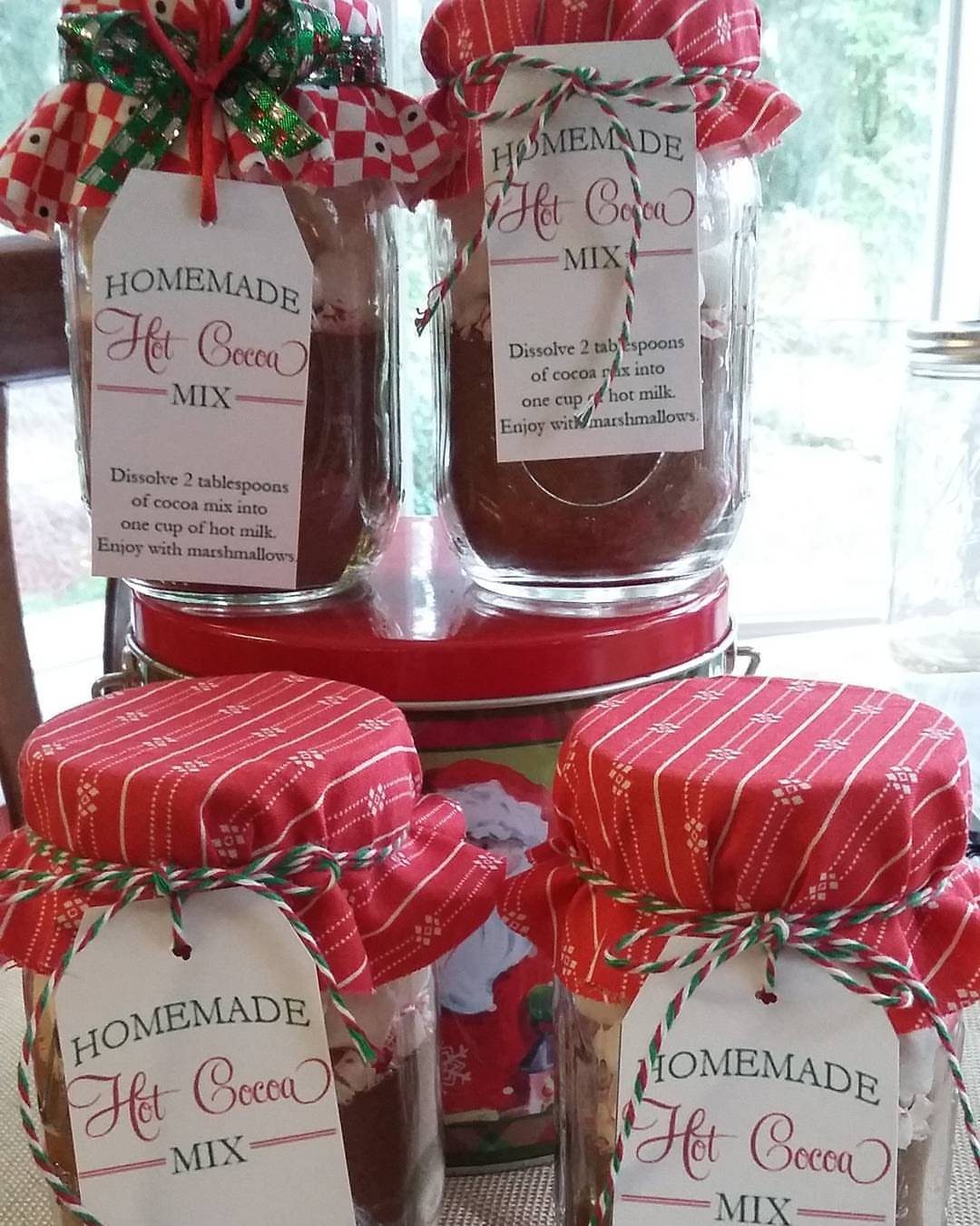 Mason jars filled with homemade hot cocoa mix, topped with red fabric lids.