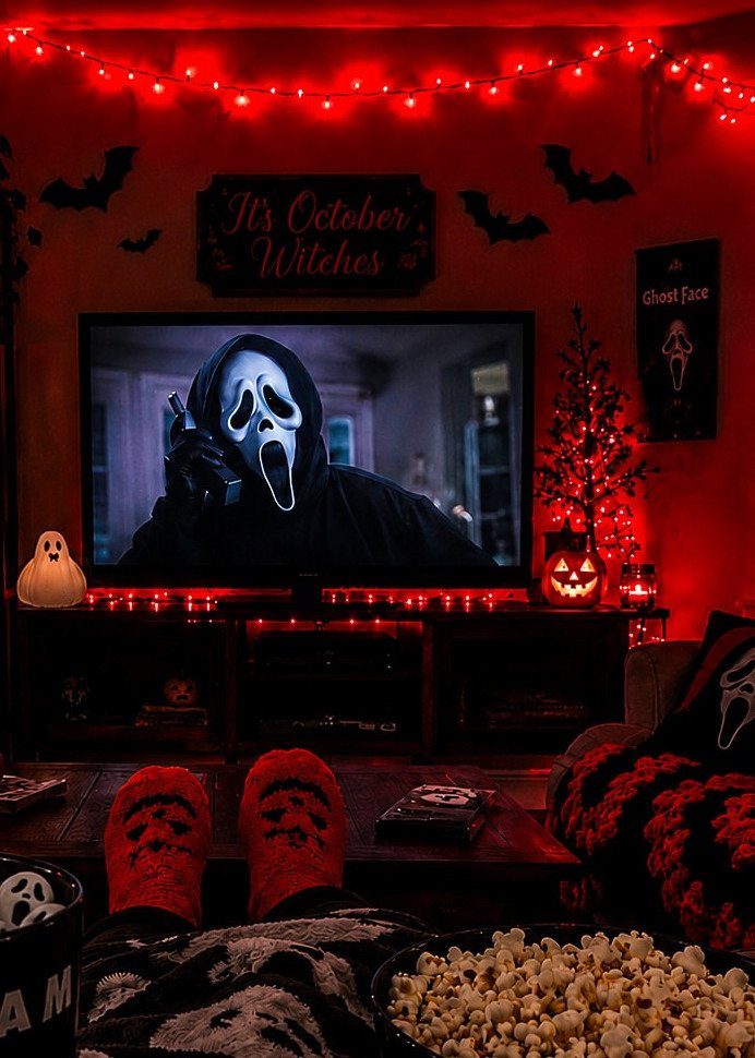 Cozy living room setup with popcorn and Ghostface socks watching a horror movie.