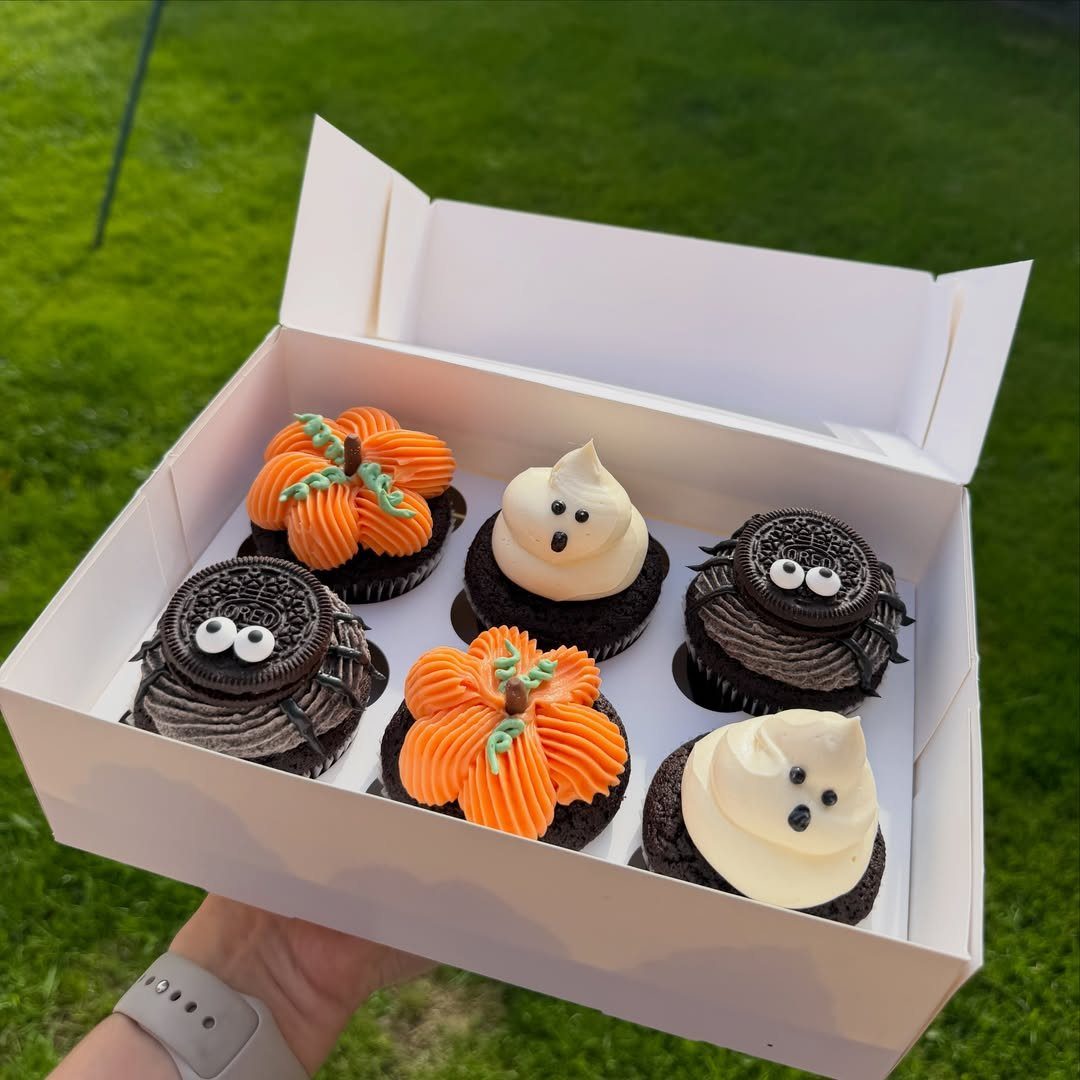 Halloween Food Gifts: 16 Sweet and Spooky Ideas 13 Halloween cupcakes shaped like pumpkins, ghosts, and spiders in a white gift box.