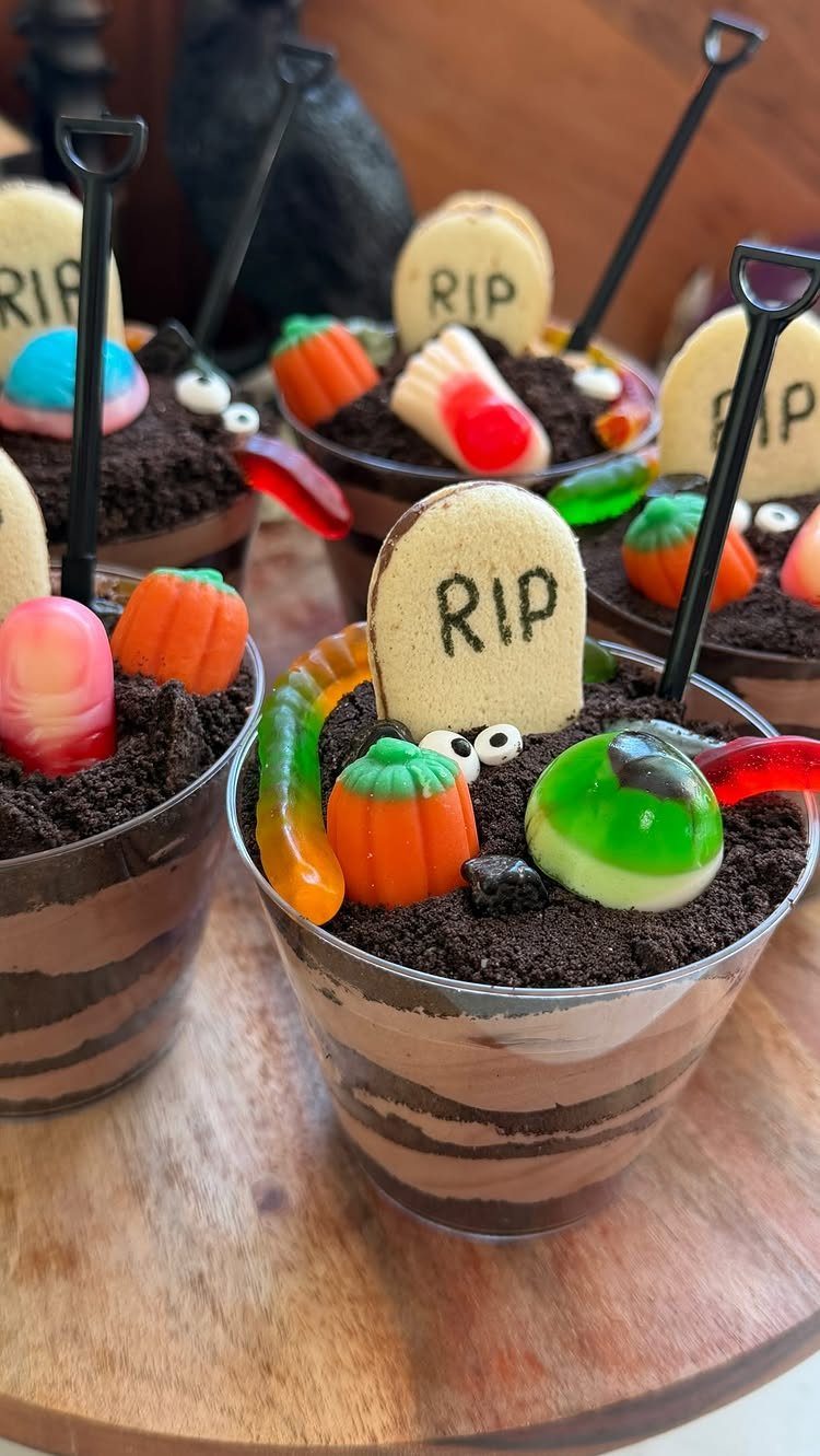 Halloween Food Gifts: 16 Sweet and Spooky Ideas 4 Halloween dirt cups with chocolate pudding, cookie crumbs, gummy worms, and RIP tombstones.