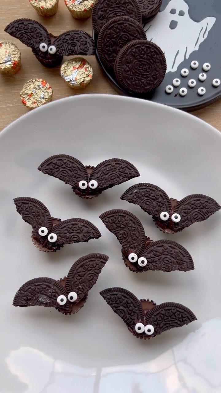 Halloween Food Gifts: 16 Sweet and Spooky Ideas 14 Chocolate bat treats made from cookies and candy eyes on a white plate.