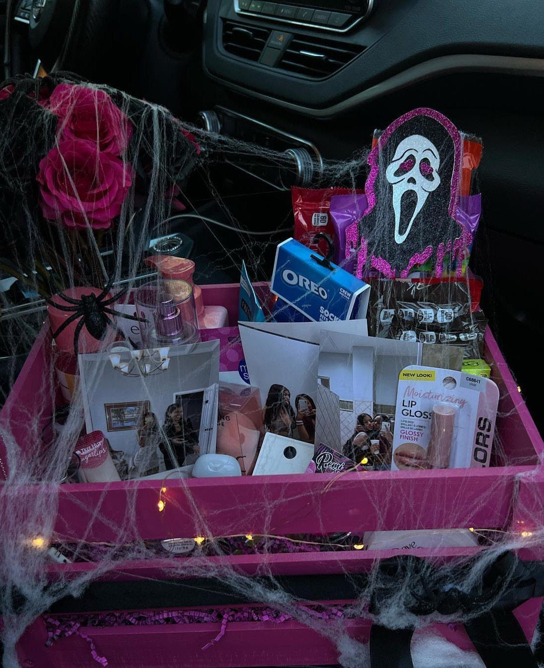 Pink gift basket with Halloween treats, spider webs, and a Ghostface mask cutout.