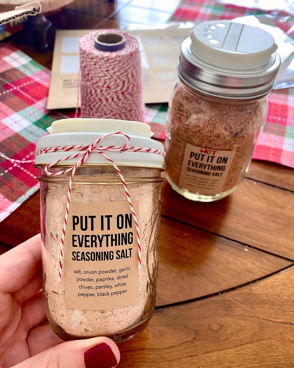 5 Homemade Christmas Gifts for Dad You Can Make 5 Glass jars of homemade seasoning salt with labels and red white twine bows.
