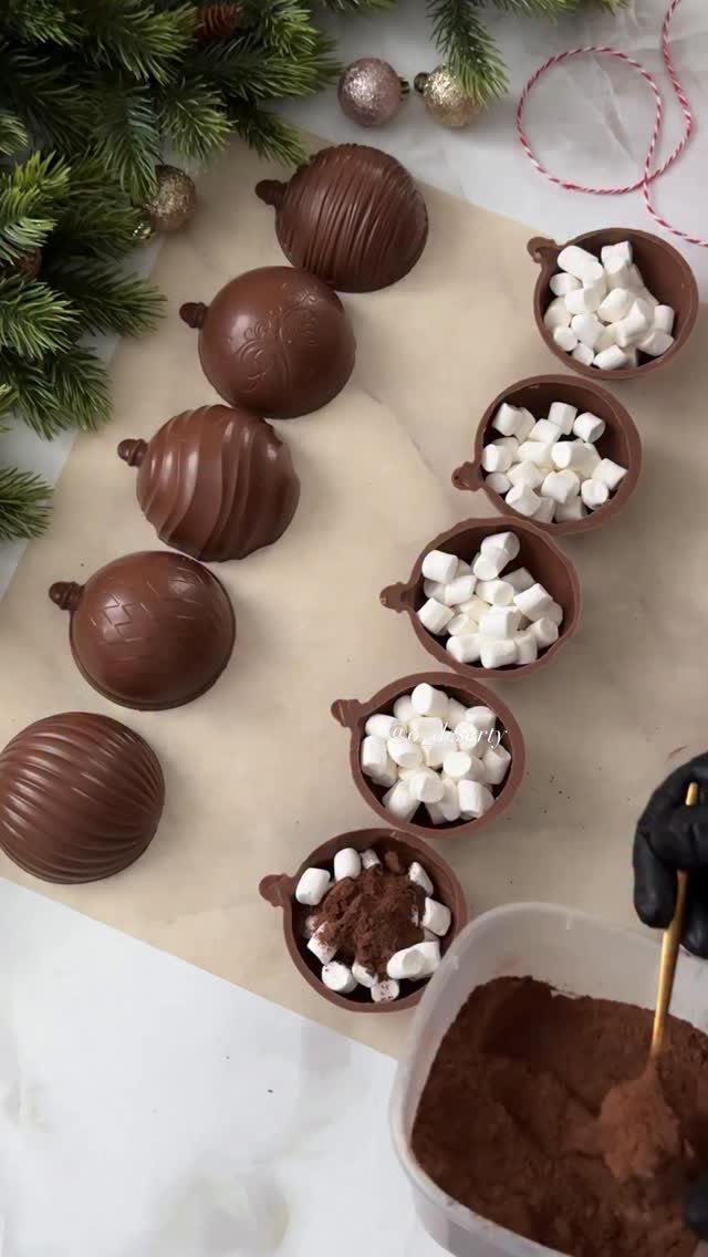 13 Homemade Gift Ideas for Coworkers They'll Use 2 Chocolate spheres and bowls filled with marshmallows and cocoa powder on parchment paper.