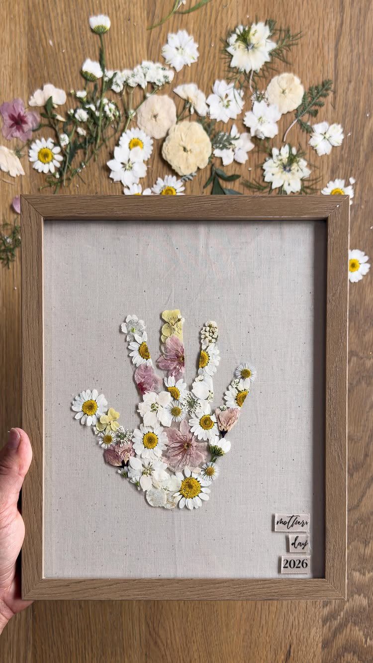 Pressed flower handprint art in a wooden frame for Mother's Day gift.