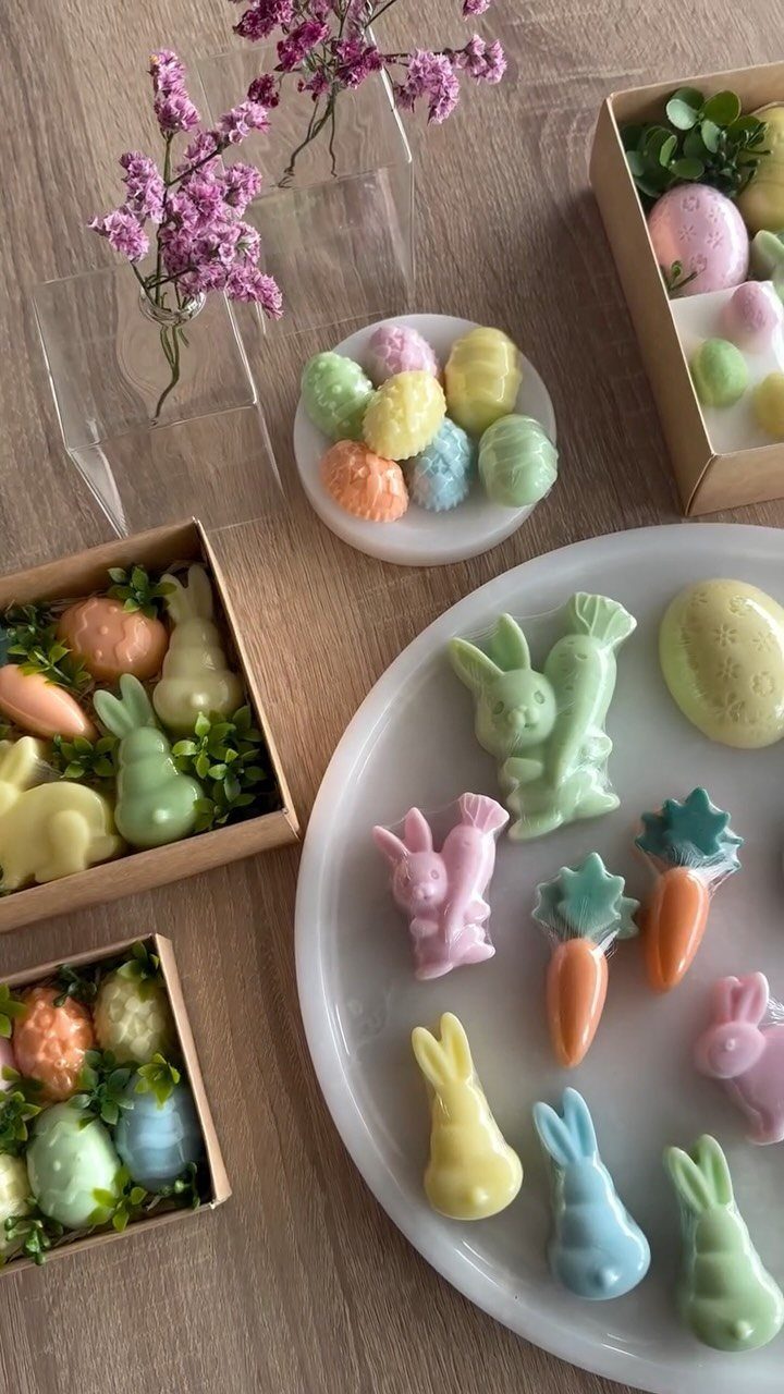 Pastel bunny and carrot shaped soaps arranged on a plate and in boxes.