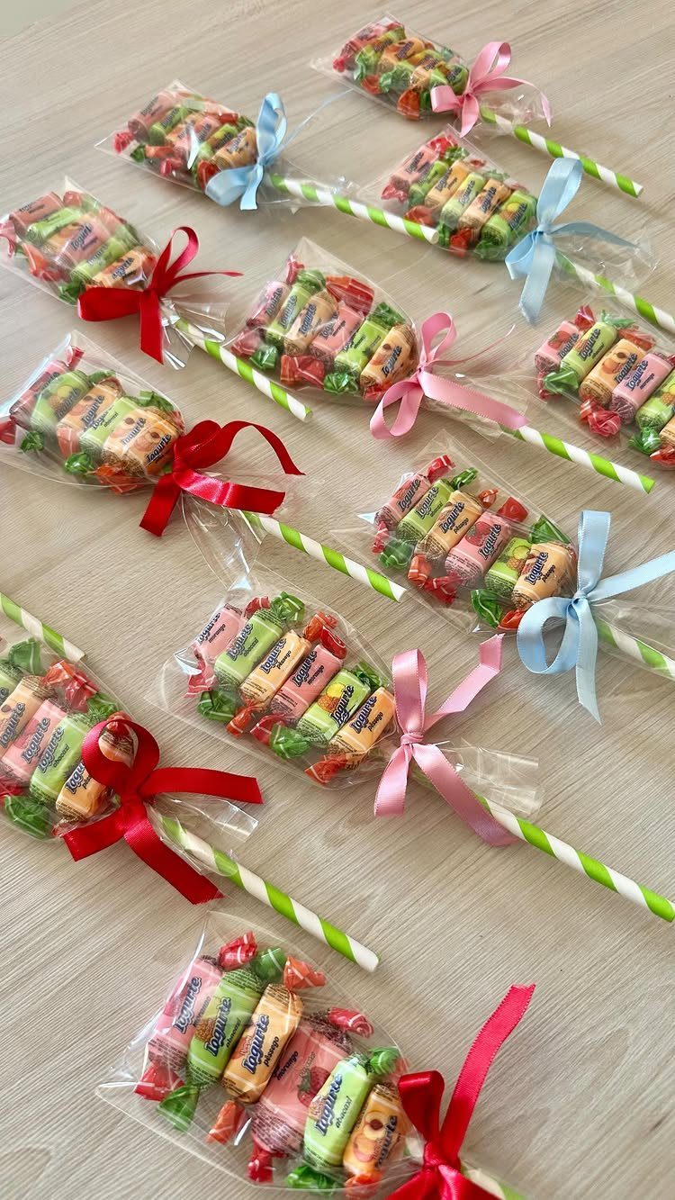 Carrot-shaped candy bags made with colorful sweets, ribbons, and striped straws.