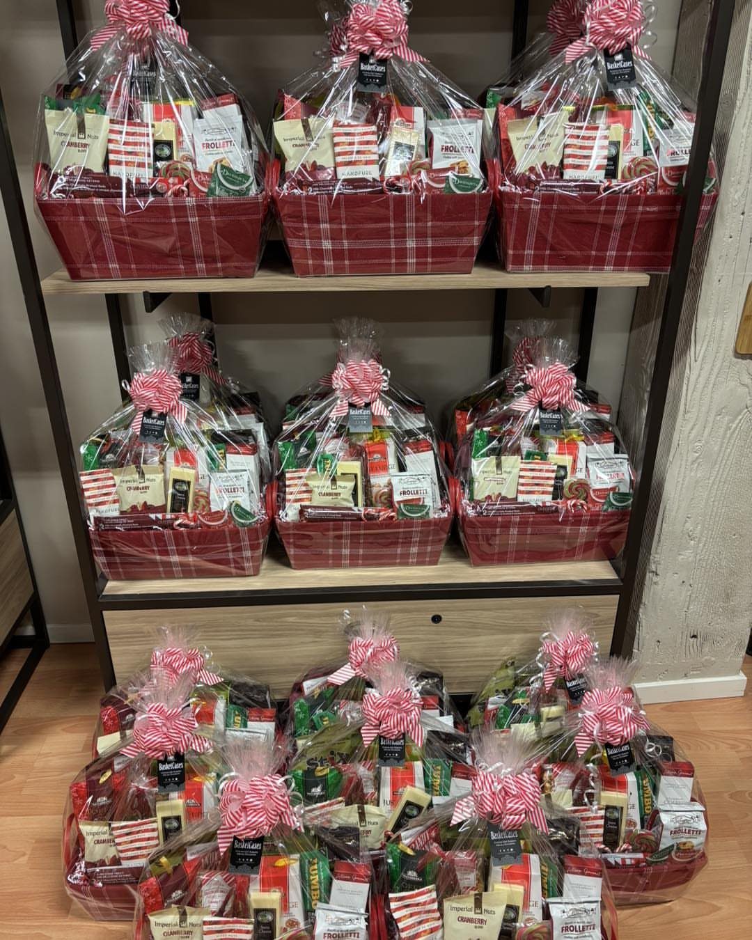 Red plaid gift baskets filled with gourmet treats wrapped in clear cellophane bows.