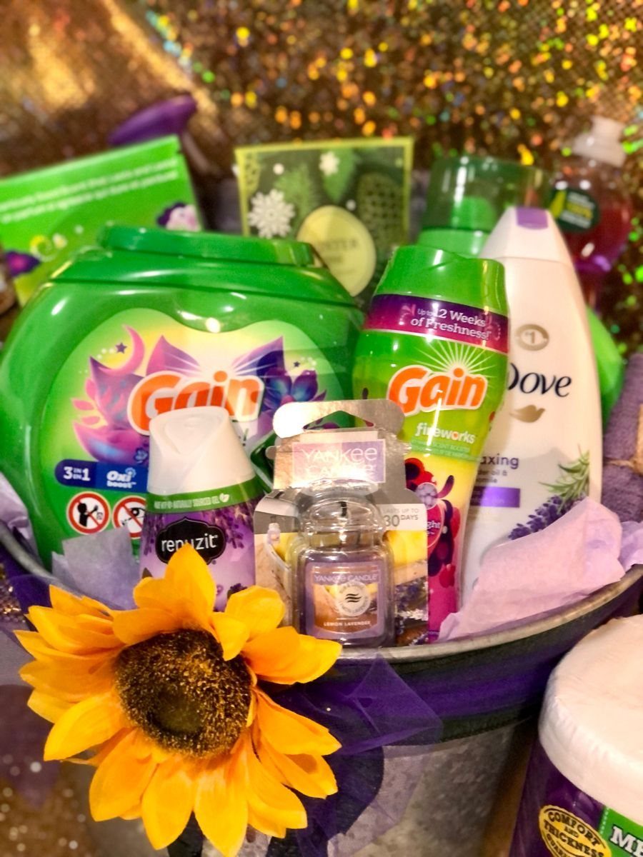 Laundry products in a metal bucket with a yellow sunflower and purple tissue.