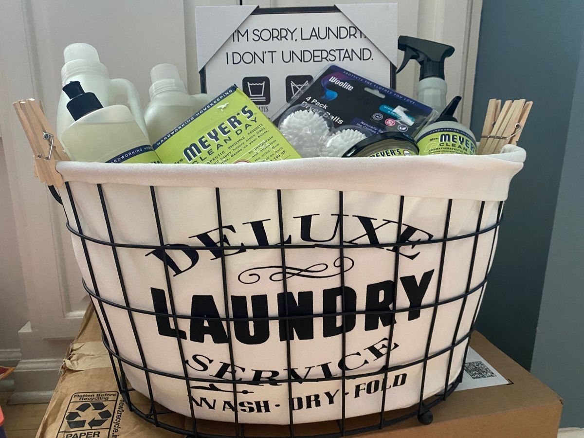 Laundry basket filled with detergent bottles and cleaning supplies for a gift set