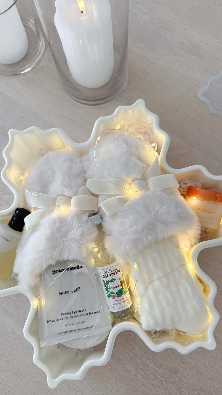 6 Meaningful Christmas Gifts for People You Love 2 White snowflake tray with fluffy slippers, skincare products, and fairy lights for relaxation.