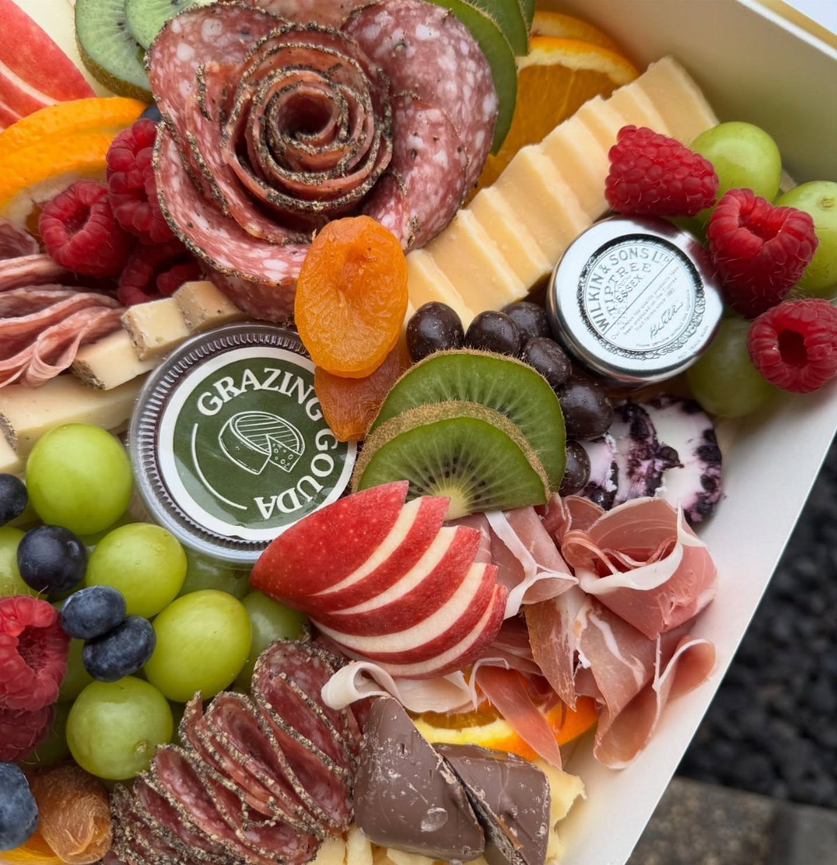 11 Mother in Law Birthday Gift Ideas She Will Actually Use 9 Charcuterie gift box with salami roses, assorted cheeses, fresh fruits, and cured meats.