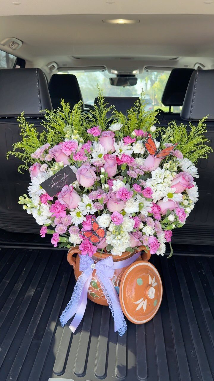 18 Mothers Day Gifts to Make: Easy Handmade Ideas for Mom 2 Pink and white flower arrangement in a terracotta pot inside a car trunk.
