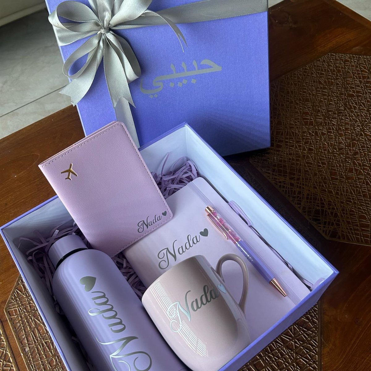 17 Personalized Gifts for Friends: Ideas for Every Budget 5 Purple personalized gift set with passport holder, mug, and bottle featuring the name Nada
