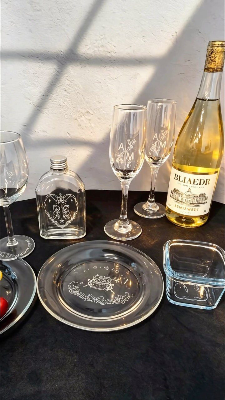 17 Personalized Gifts for Friends: Ideas for Every Budget 10 Engraved champagne flutes and wine glasses next to a bottle of white wine.