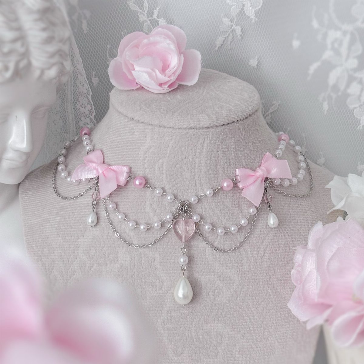 24 Pink Christmas Gift Ideas from Cozy to Glam 18 Pink and pearl choker necklace with bows on a grey mannequin bust