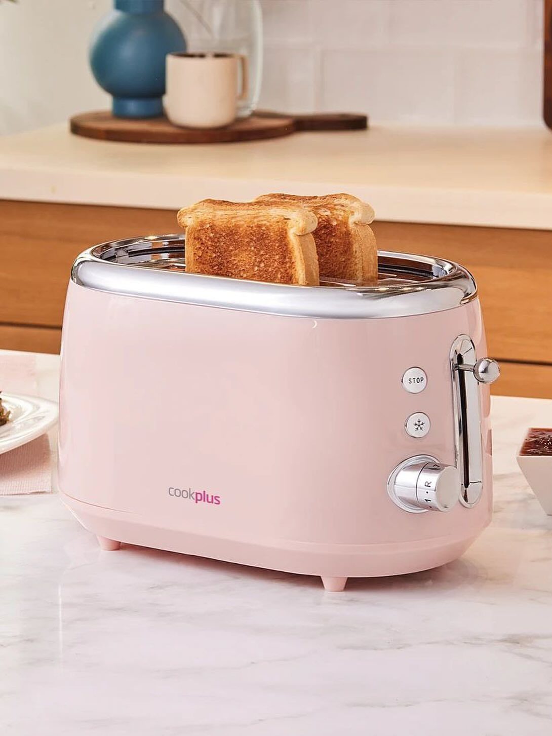24 Pink Christmas Gift Ideas from Cozy to Glam 21 Pink retro toaster with toasted bread on a white marble kitchen counter