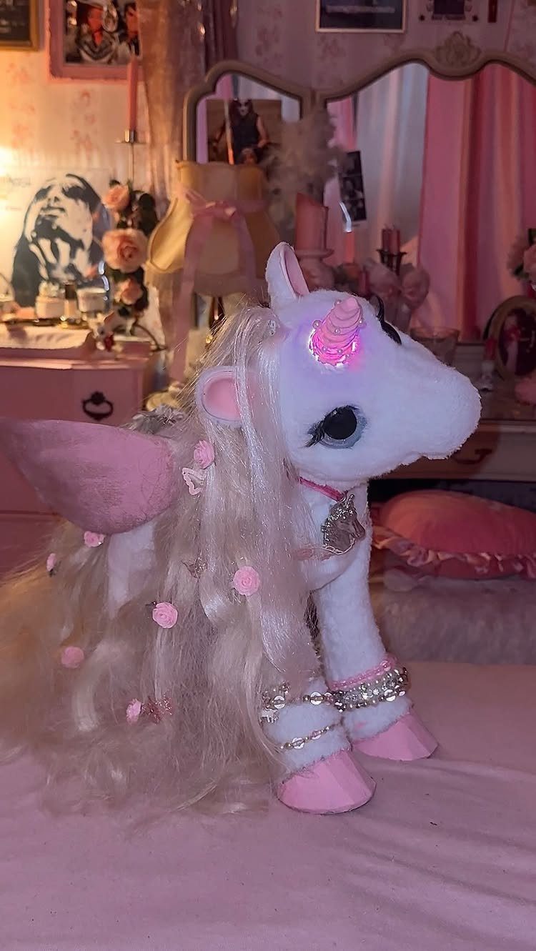 24 Pink Christmas Gift Ideas from Cozy to Glam 4 White plush unicorn with a glowing pink LED horn in a pink bedroom