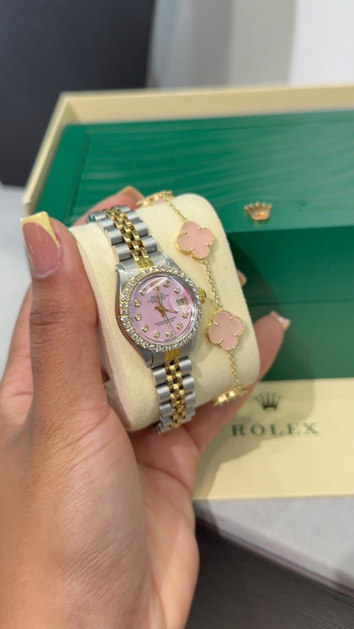 24 Pink Christmas Gift Ideas from Cozy to Glam 19 Silver and gold watch with pink face and pink clover bracelet on cushion