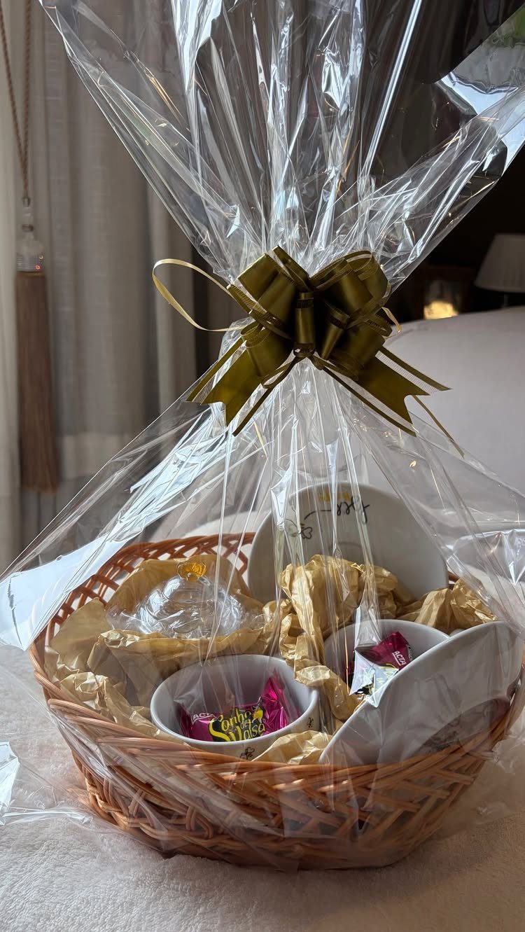 8 Senior Citizen Gift Basket Ideas for Grandparents 7 Wicker gift basket wrapped in cellophane with a gold bow and candies.