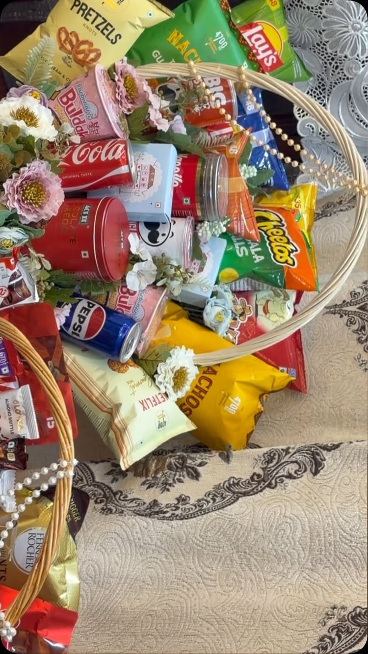 8 Senior Citizen Gift Basket Ideas for Grandparents 3 Gift basket filled with assorted snacks and drinks decorated with small flowers.