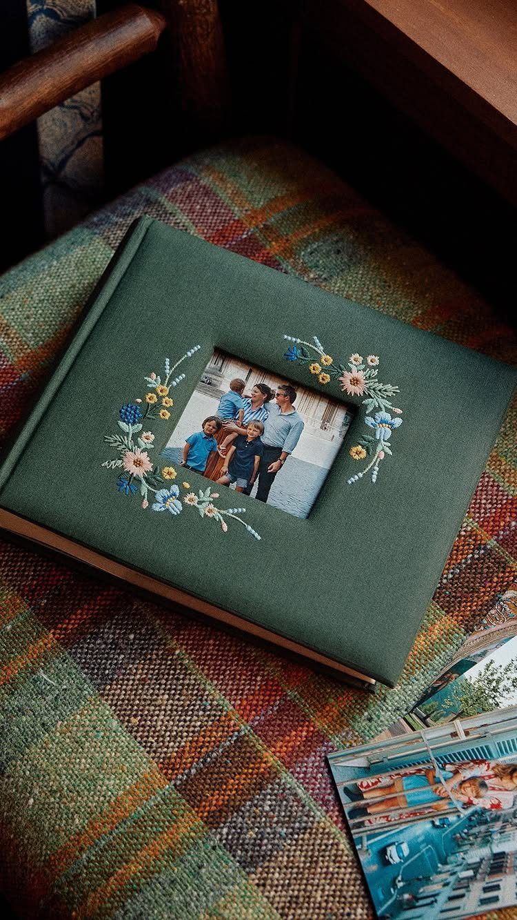 Green fabric photo album with embroidered flowers and a family photo on the cover