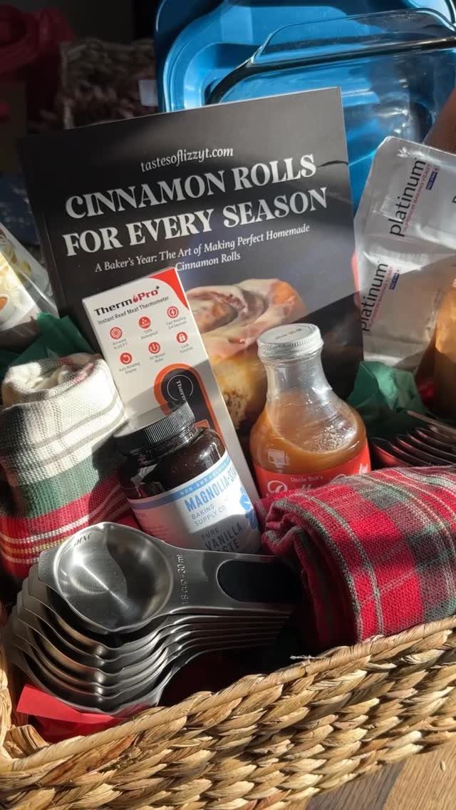 12 Silent Auction Gift Basket Ideas for Any Fundraiser 10 Woven gift basket containing a cinnamon roll cookbook, measuring cups, and baking ingredients.