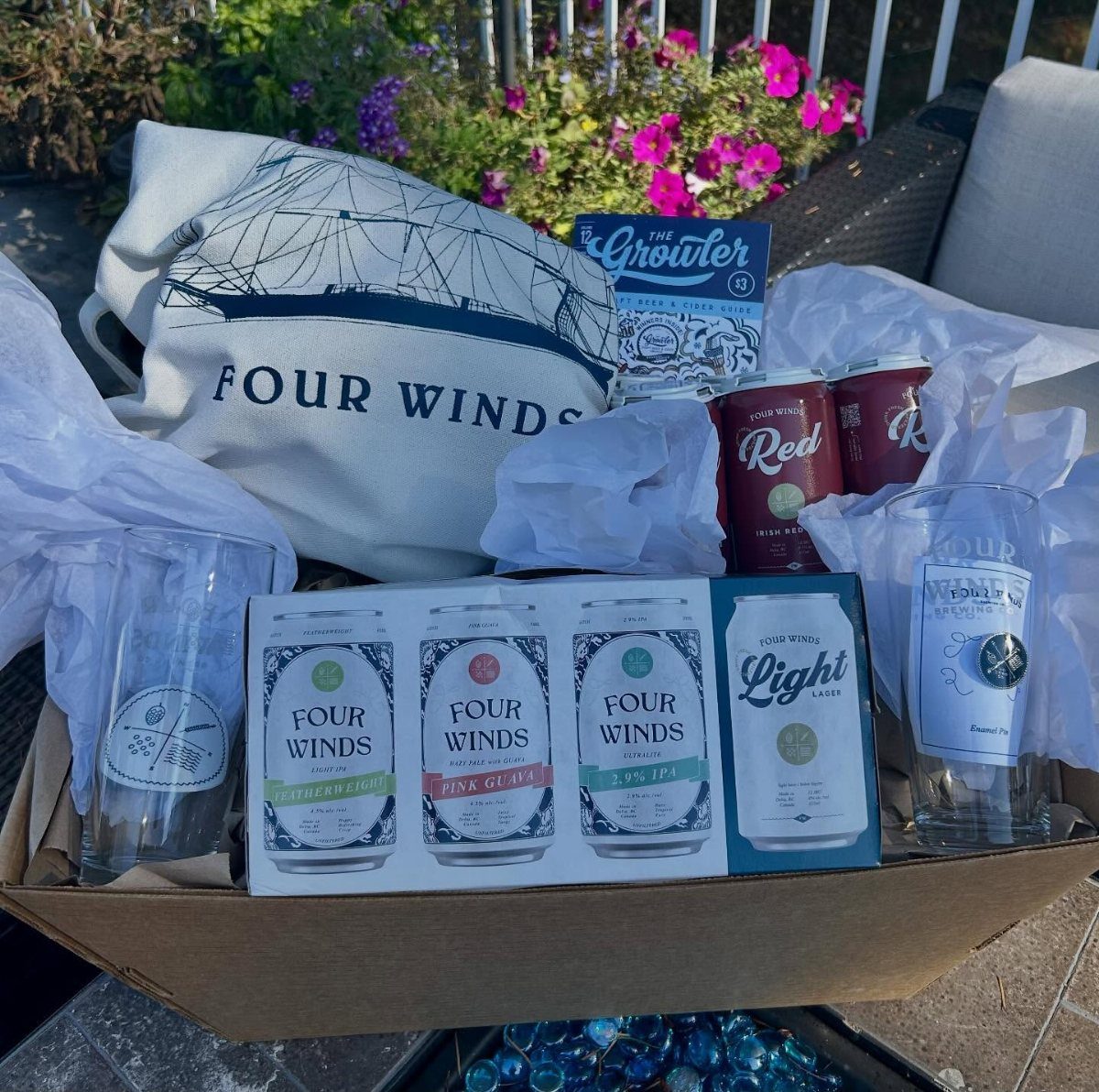 12 Silent Auction Gift Basket Ideas for Any Fundraiser 9 Beer gift basket with Four Winds cans, glasses, and a branded white bag.