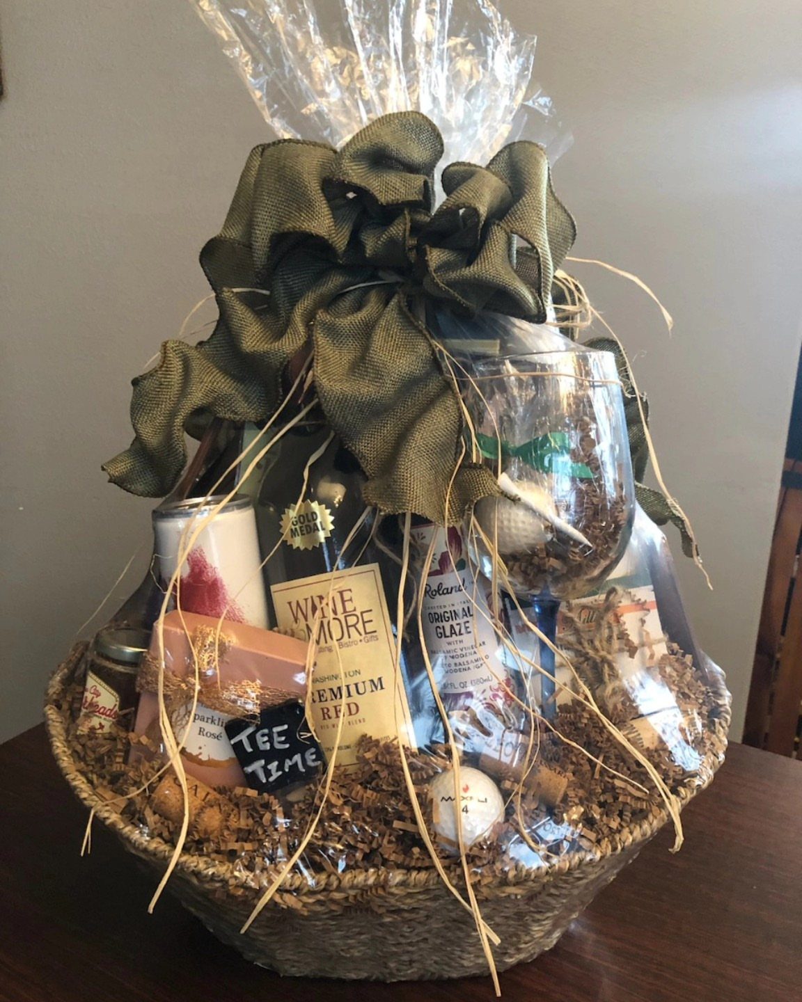 12 Silent Auction Gift Basket Ideas for Any Fundraiser 1 Wine gift basket with a bottle of red wine, glass, and green bow.