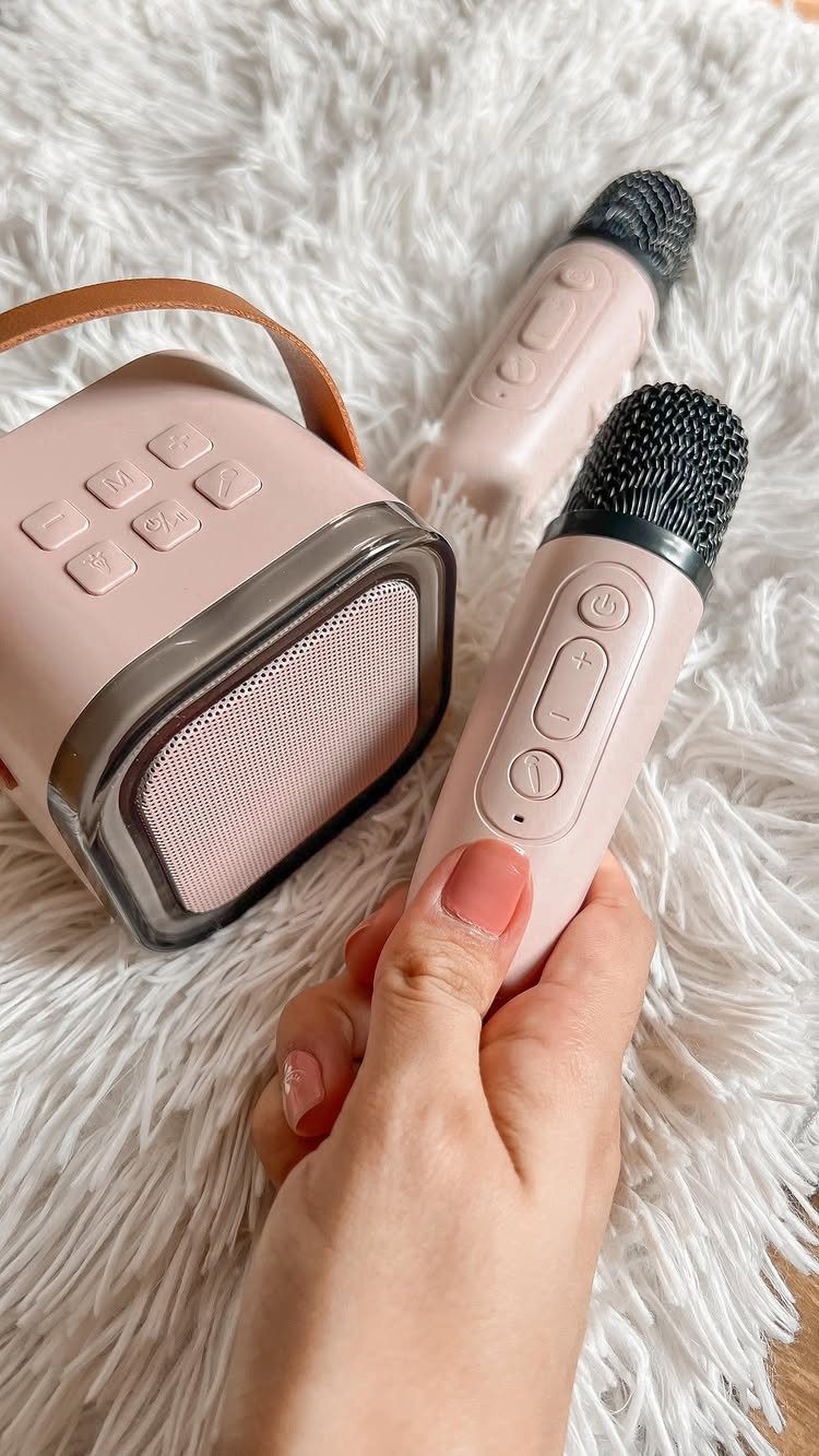 8 Small Gifts for Family That Everyone Will Enjoy 7 Pink handheld karaoke microphones and a matching portable speaker on white shaggy fur.