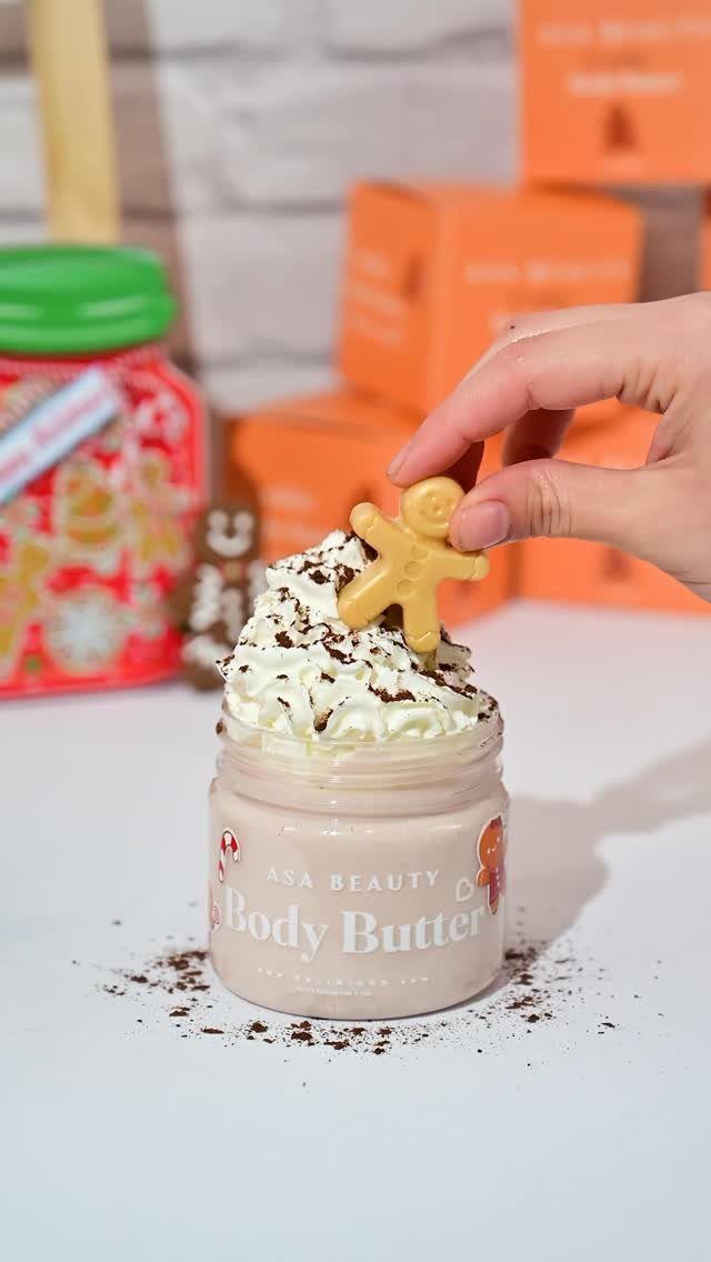 Gingerbread body butter in a jar topped with whipped cream and a cookie.
