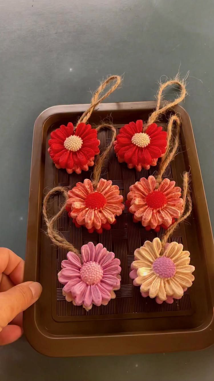 11 Spa Day Gift Basket Ideas for Relaxing at Home 3 Flower-shaped handmade soaps in various colors arranged on a brown plastic tray.