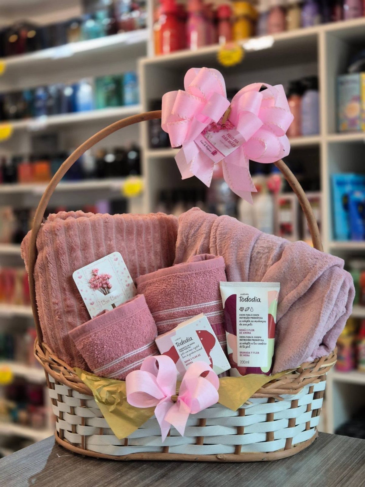 11 Spa Day Gift Basket Ideas for Relaxing at Home 10 Spa gift basket with pink towels, skincare products, and pink bows in a store.