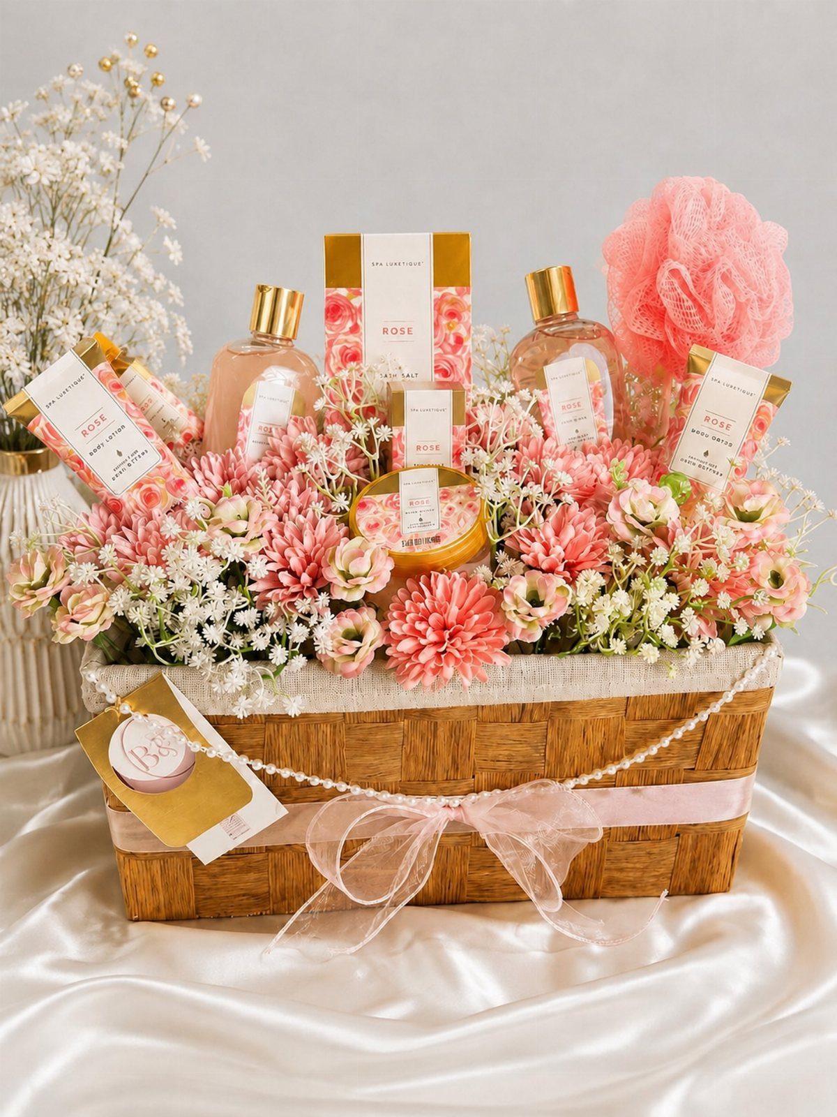 Spa Gift Basket Ideas: 8 Picks for Relaxing at Home 5 Woven gift basket filled with pink flowers, spa products, and a pink loofah.